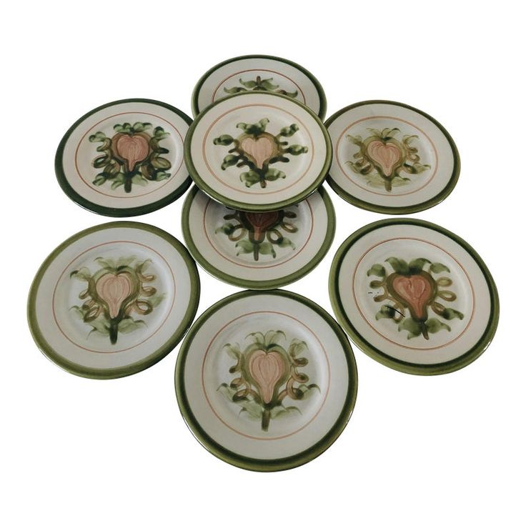 six green and white plates with pink hearts on the center one has a heart in the middle