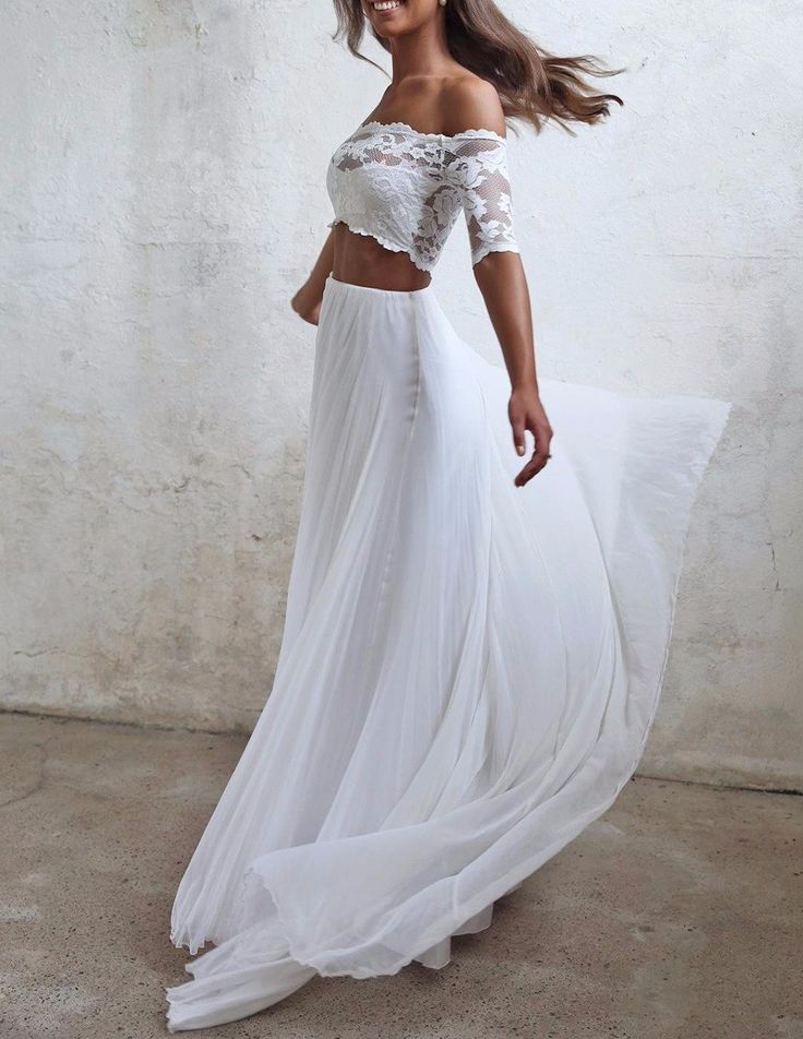 a woman in a white dress is posing for the camera with her hair blowing in the wind