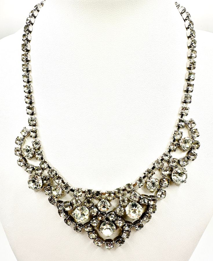 A stunning ladies vintage 80's crystal necklace bib, pre owned  fantastic condition  in a classic design  a single strand cz layed form a main fram  from which 6 oval cz studded drops hang  with 10 larger round faceted cut rhinestone are set  all set on a silver tone metal alloy base with a single hoop clip fastening great condition, no stones missing  a perfect statement item for any even  perfect for a classic bride to be  size. 20 cm  total length 38 cm  width 3 cm  total weight. 34 grams Evening Costume Jewelry Bridal Necklace, Elegant Necklaces With Sparkling Stones For Vintage Events, Oval Costume Jewelry Necklace For Wedding, Oval Crystal Necklaces For Parties, Wedding Costume Jewelry Necklace, Classic Crystal Necklaces For Party, Classic Crystal Necklace For Party, Crystal Embellished Jewelry For Vintage Events, Crystal Jewelry For Vintage Events