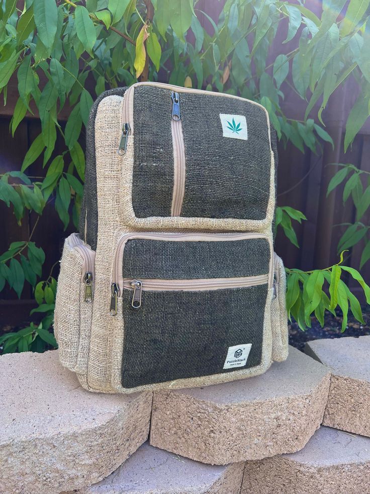 "PuzzleStack presents the Sainik Multipocket Laptop Backpack - a must-have for your everyday needs. Sainik translates to 'soldier' from Nepali to English. True to its name, the Sainik Multipocket Hemp Backpack exhibits strength and sturdiness. This eco-friendly backpack is crafted from organic hemp and cotton, showcasing a stunning color combination with natural khaki hemp and dyed green hemp. Designed with functionality in mind, it boasts two large and spacious compartments, providing ample roo Practical Rectangular Backpack For Trips, Green Backpack With Multiple Pockets For Everyday Use, Eco-friendly Shoulder Bag With Pockets For Travel, Eco-friendly Travel Shoulder Bag With Pockets, Travel Bags With Pockets In Natural Color, Eco-friendly Beige Backpack, Casual Adventure Bags With Multiple Pockets, Bohemian Backpack In Natural Color For Everyday Use, Green Rectangular Backpack With Pockets