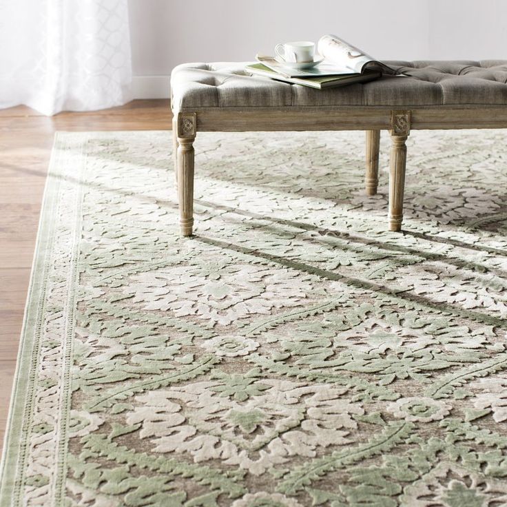 a bench sitting on top of a rug next to a window