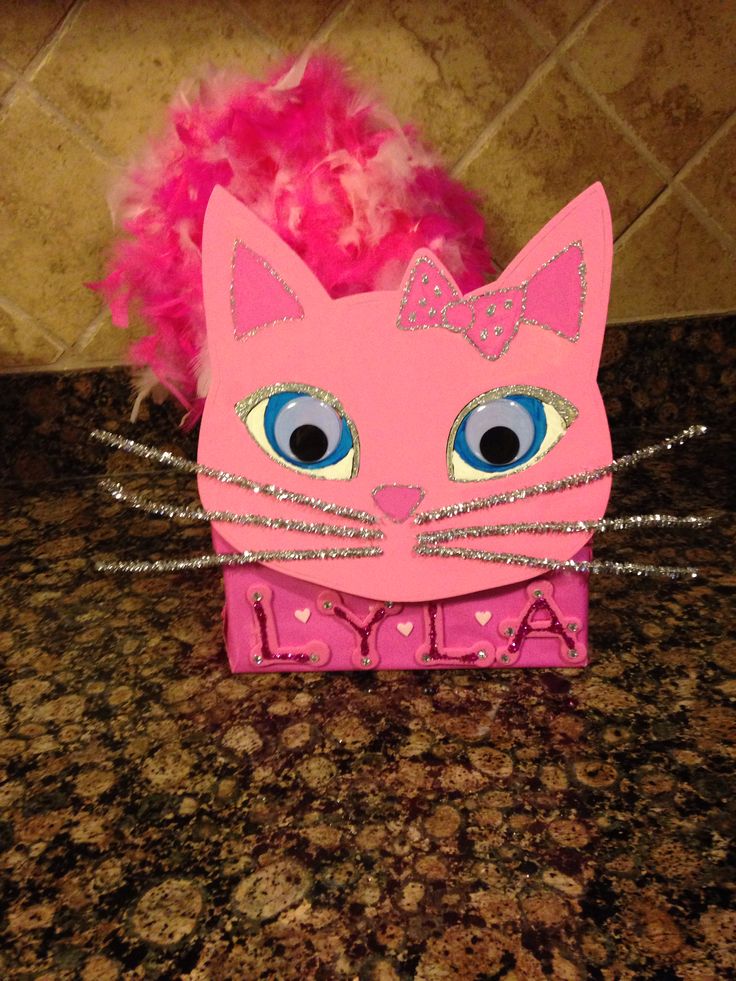 a pink cat with big blue eyes sitting on top of a counter