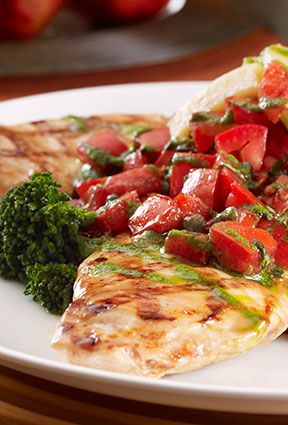 a white plate topped with meat and veggies on top of a wooden table