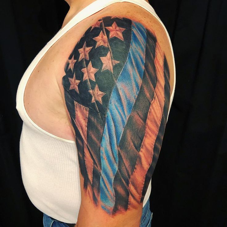 an american flag tattoo on the upper half of a woman's arm and shoulder