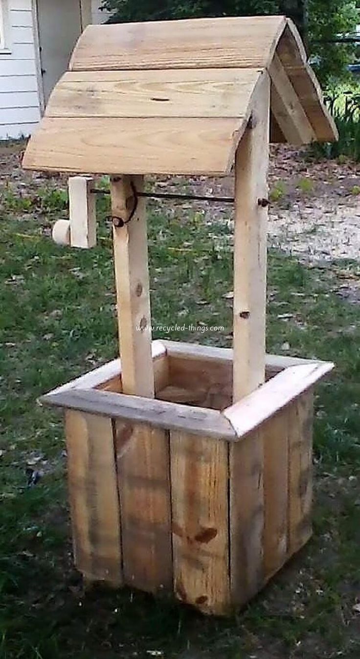 a wooden bird house sitting in the grass