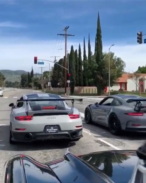 two cars are stopped at an intersection with traffic lights