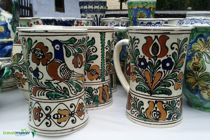 many colorful cups are lined up on a table