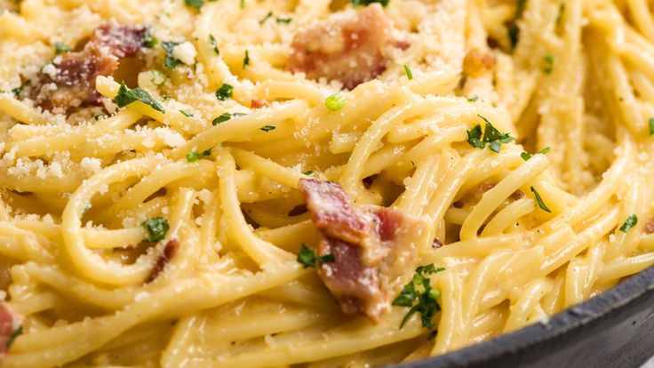 pasta with bacon and parmesan cheese in a skillet, ready to be eaten