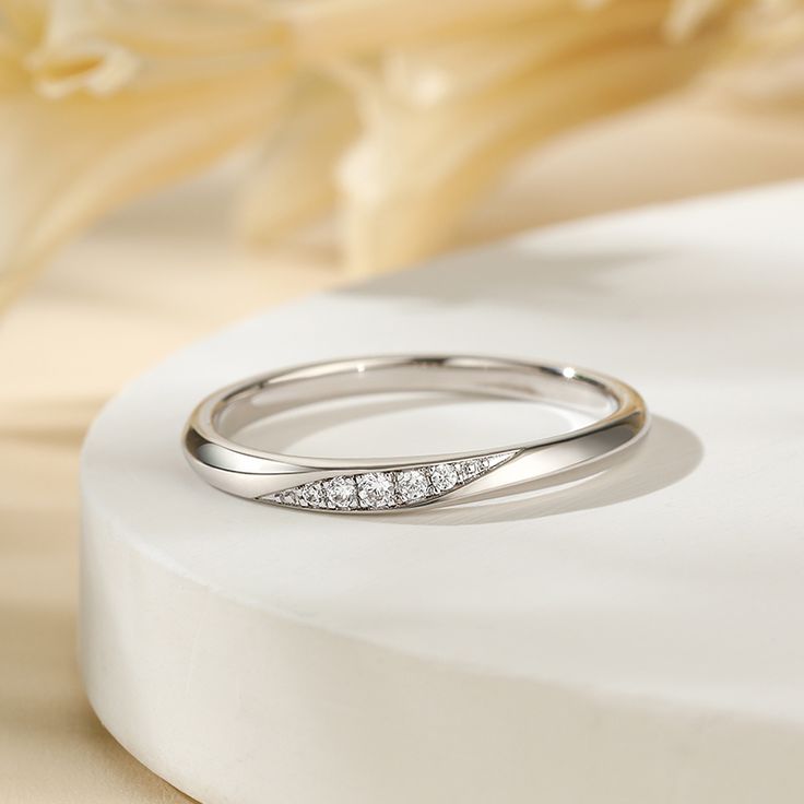 Simply and chic, this band is a clever accessory you will love. Featuring white stones, this band is an elegant symbol of your marital commitment. Buffed to a brilliant luster, this comfort-fit wedding band  will make your vows shine.Carat Weight: 0.086 ctStone Size: 1.1,1.3,1.5 mmStone Type: Jeulia® StoneNumber of Stones: 5 Stone Color: Diamond WhiteStone Shape: RoundWeight: 1.6 gWidth: 1.8 mmHeight: 1.8 mmThickness: 1.1 mmMaterial: 925 SilverPlating Color: Silver Modern Wedding Band Jewelry, Elegant Formal Band Rings, White Diamond Eternity Band For Wedding, Modern Round Band Wedding Jewelry, Minimalist White Gold Channel Set Wedding Ring, Minimalist Channel Set Round Cut Wedding Ring, Modern Wedding Eternity Band With Brilliant Cut, Modern Round Cut Wedding Bands, Elegant Adjustable Band Jewelry