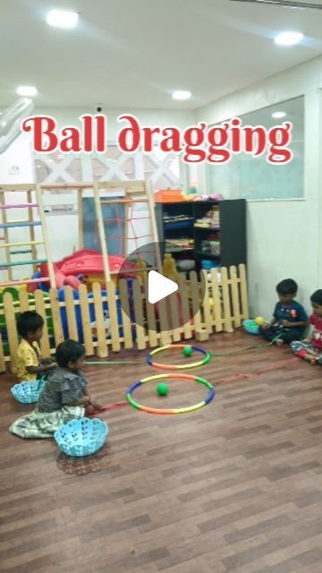 two children playing with toys in a play room that says ball dragging on the wall