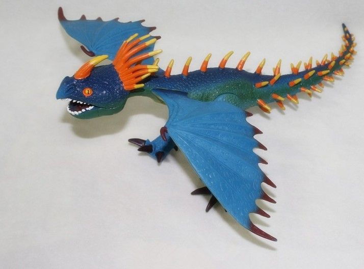 a toy blue and orange dragon flying through the air