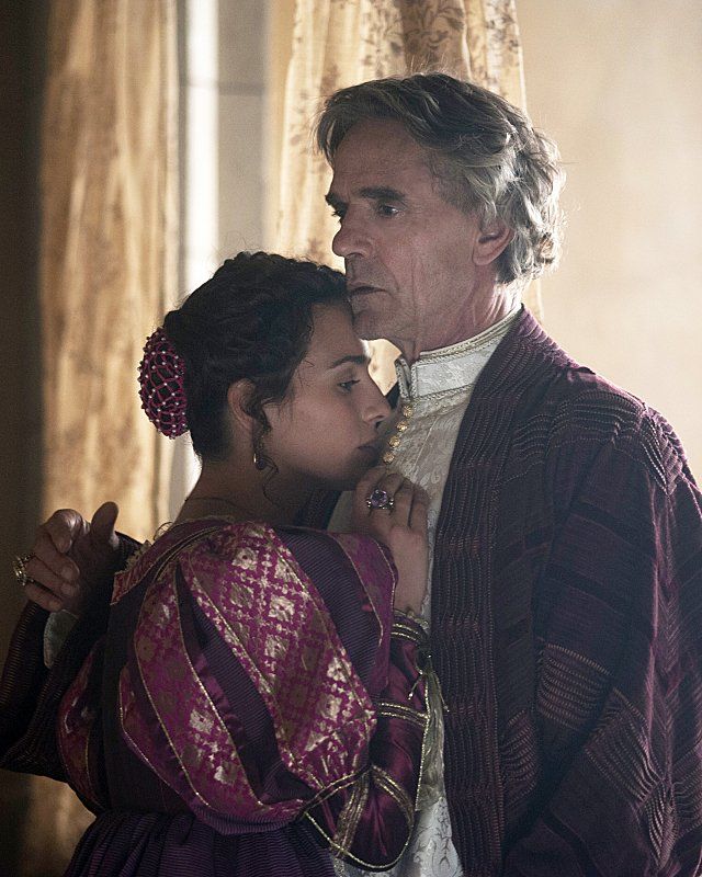 the doctor and his daughter are standing together in front of curtains, looking at each other