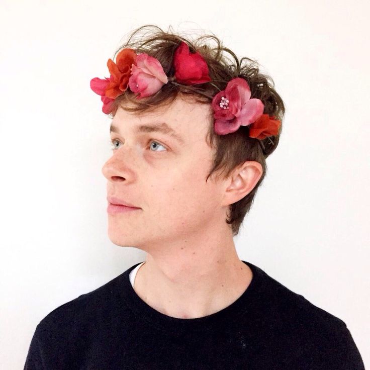 a man with flowers in his hair on twitter