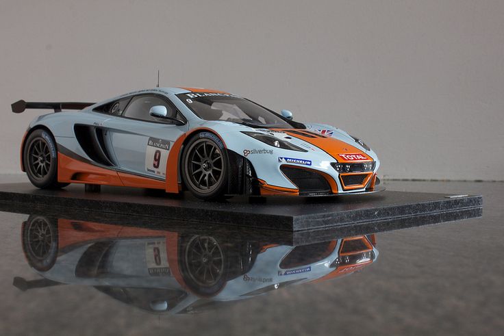 an orange and white sports car sitting on top of a table