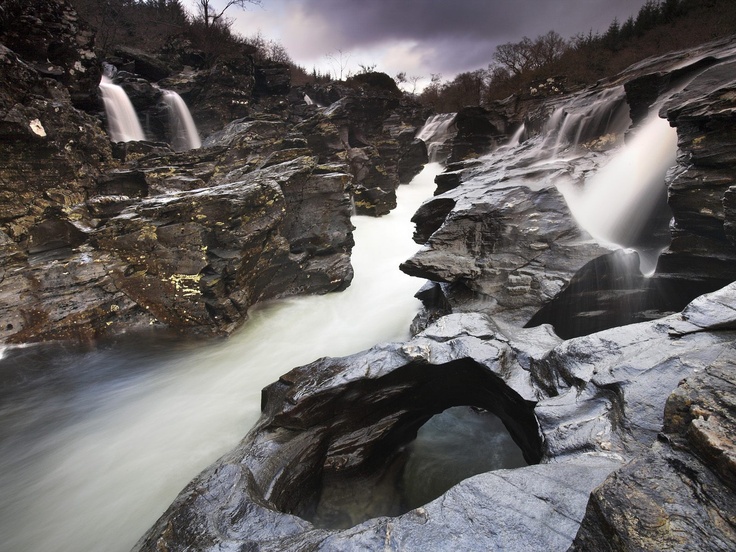 the water is rushing over the rocks and into the river to get to the falls