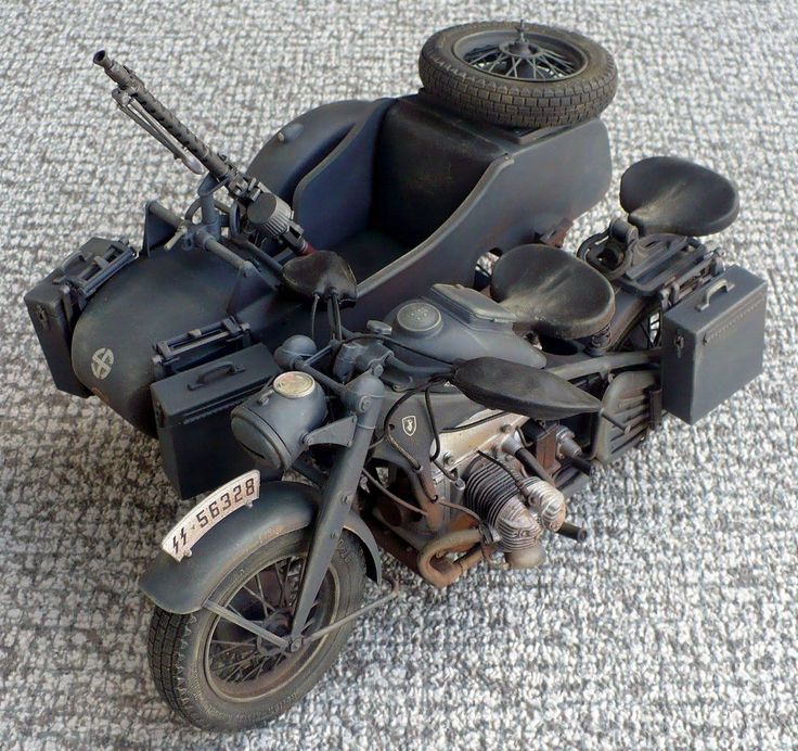 an old motorcycle is sitting on the ground with its seat up and two wheels down