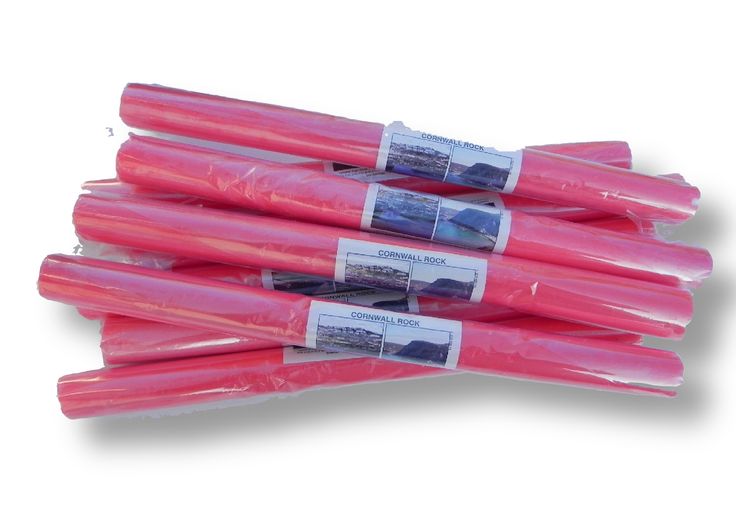 pink candles are wrapped in plastic on a white background