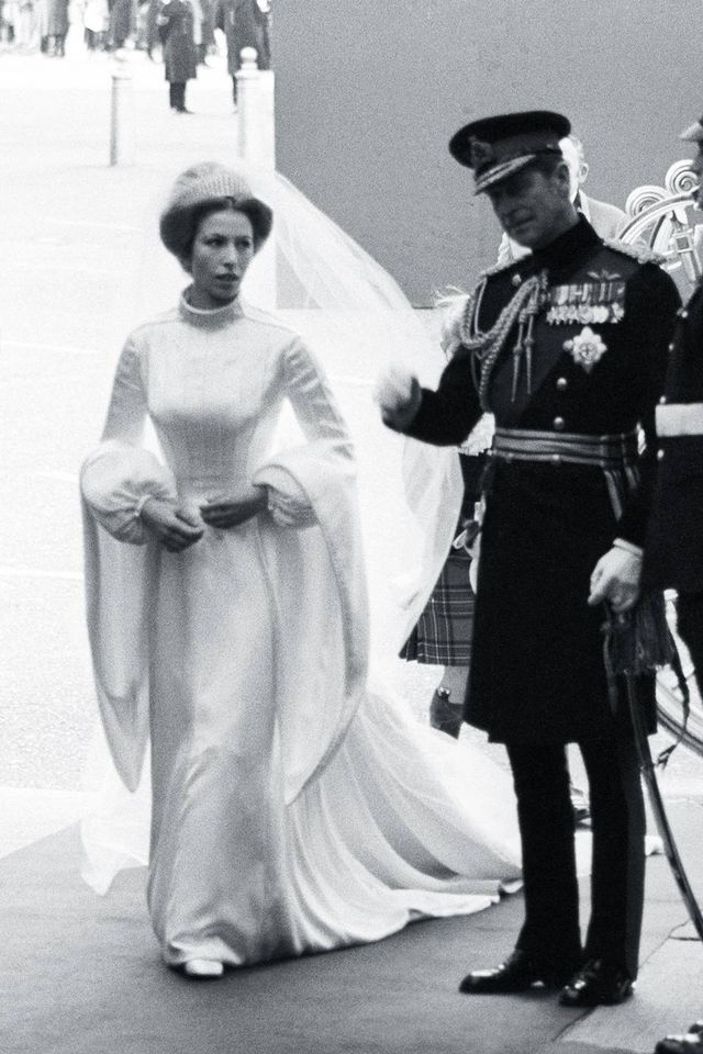 a man in uniform standing next to a woman wearing a wedding dress