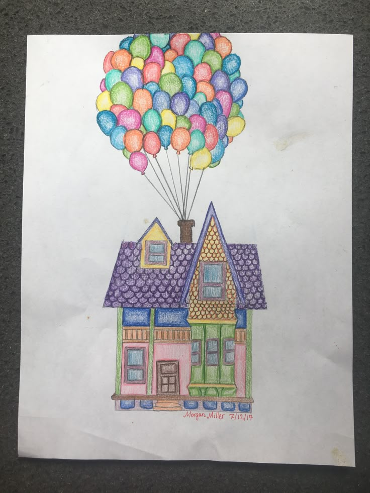 a drawing of a house with balloons in the air above it, on top of a piece of paper