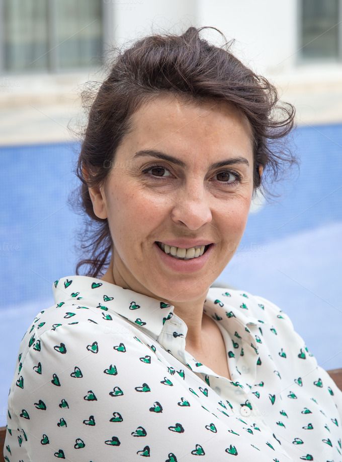 a woman sitting in a chair smiling at the camera