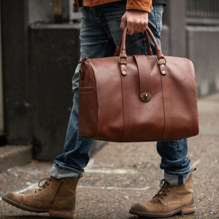 Elevate your carry-on with our newest bag the Travel Duffle. A bag that gets you anywhere you need to go, from the conference room to a weekend retreat, packing everything you need in style. Handcrafted in full-grain leather with antique brass hardware and storage compartments both inside and out. Complete with zipper closure, top strap buckle accent, smooth and sturdy handles, and removable crossbody strap. Details Double top handles Adjustable 54" crossbody strap Zipper and front clasp closure Classic Brown Duffle Bag For On-the-go, Classic Shoulder Bag With Smooth Grain For Travel, Business Leather Luggage With Leather Handles, Business Luggage With Leather Handles, Classic Smooth Grain Leather Shoulder Bag For Travel, Luxury Cognac Satchel For Travel, Leather Lined Tote Laptop Bag For Travel, Classic Tote Travel Bag For Business Trips, Cognac Tote Weekender Bag For Travel