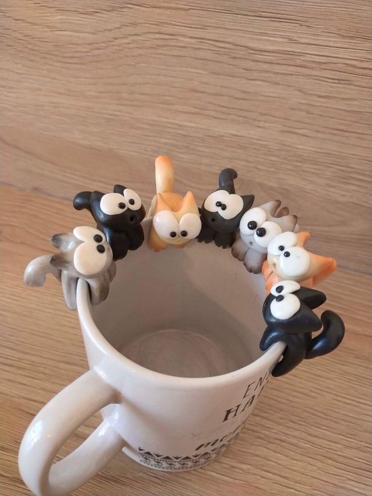 a coffee cup filled with small black and white animals