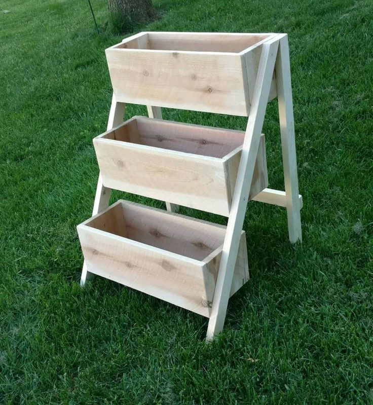 three tiered wooden shelf sitting in the grass