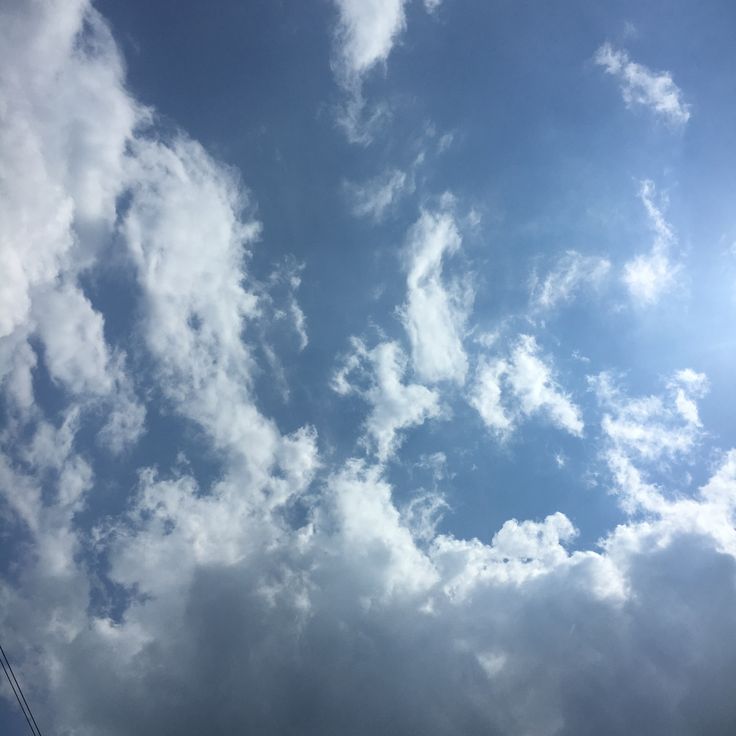 an airplane is flying high in the blue sky with white clouds and sunbeams