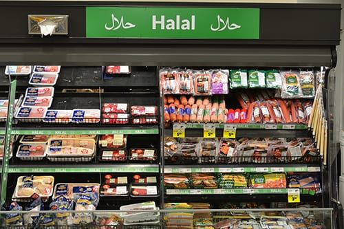 a grocery store filled with lots of food and meats on display in front of it