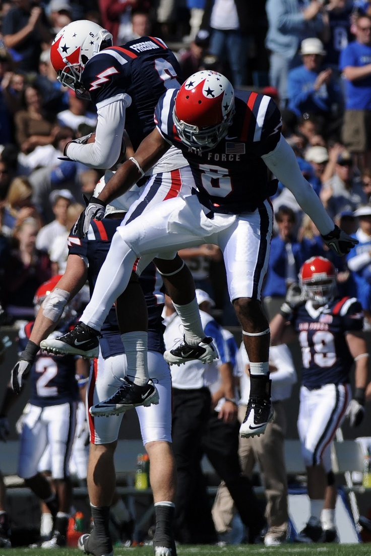 two football players jumping in the air during a game