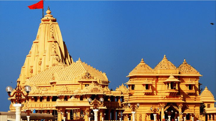 an ornate yellow building with a red flag on top and blue sky in the background