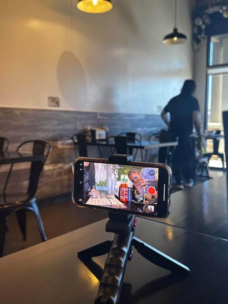 a cell phone is on a tripod in a restaurant