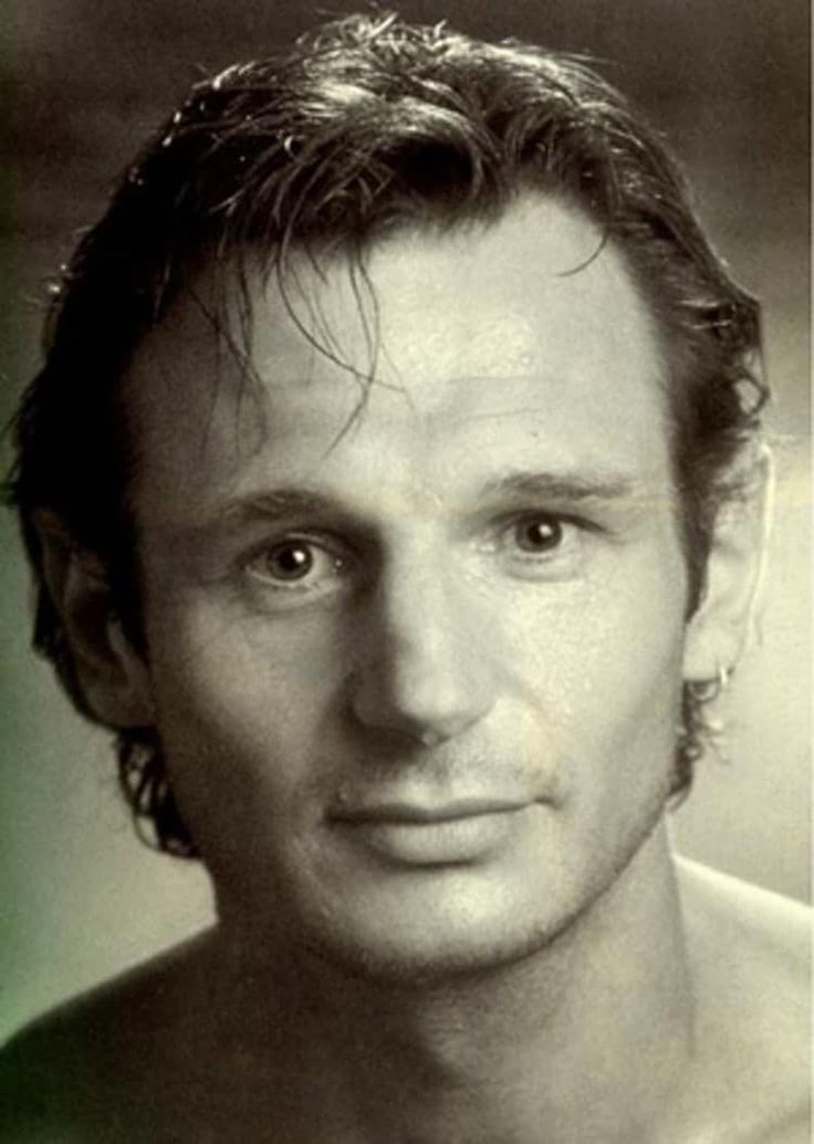 a black and white photo of a man with no shirt on, looking at the camera