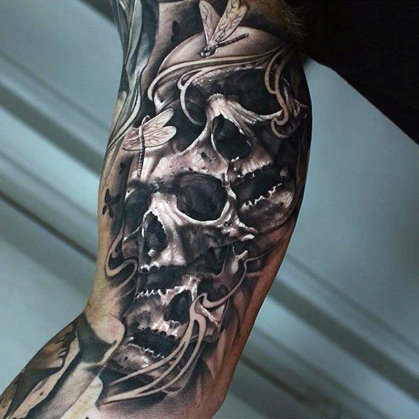 a man's leg with a skull and cross tattoo on it, in black and grey