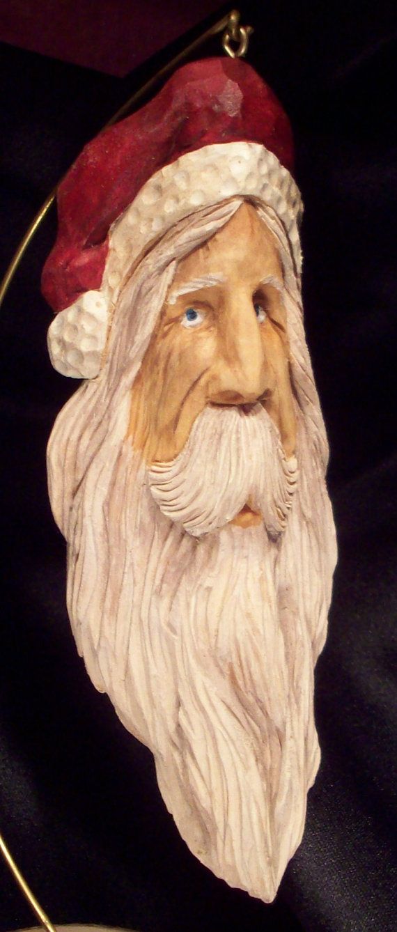 a close up of a santa clause head on a black cloth covered table with a lamp