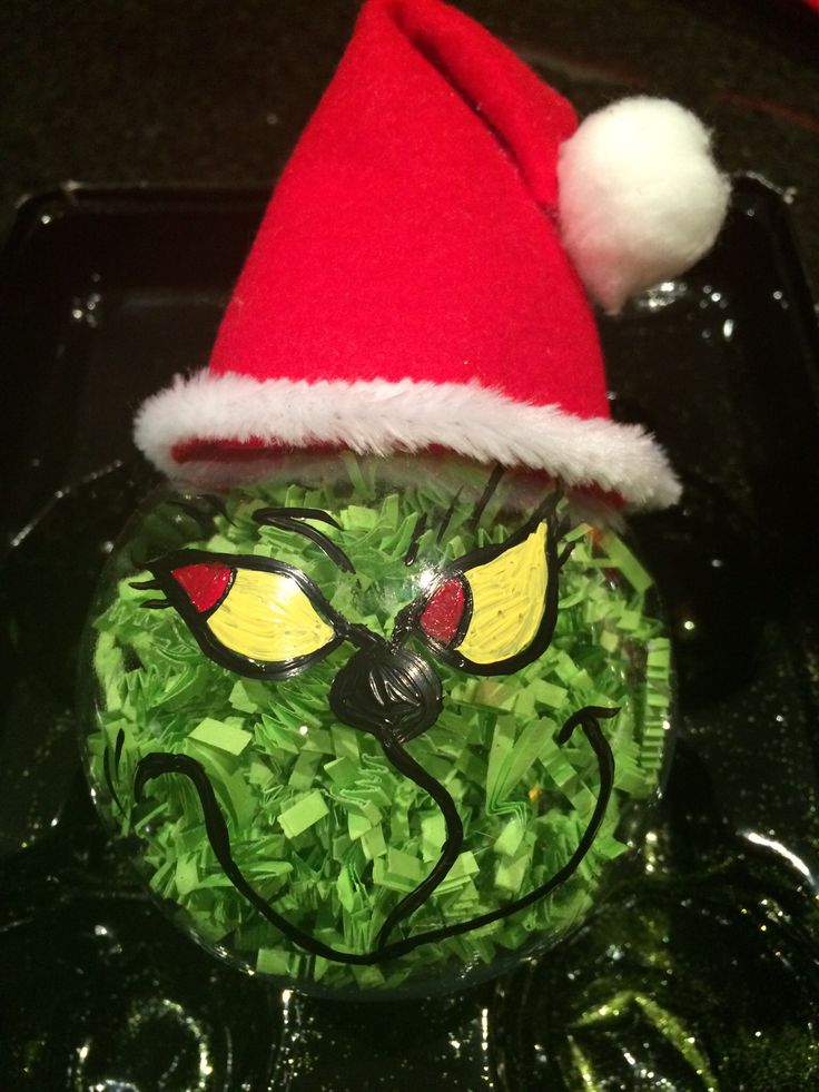 a glass bowl filled with green food wearing a santa hat