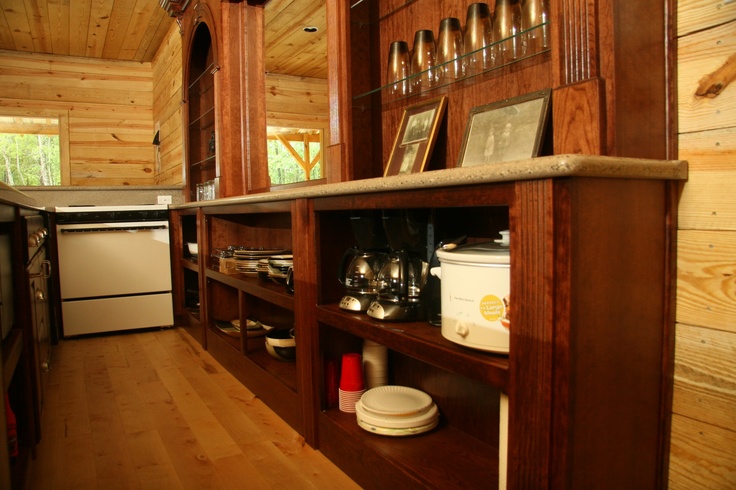 a kitchen area with wooden walls and shelves