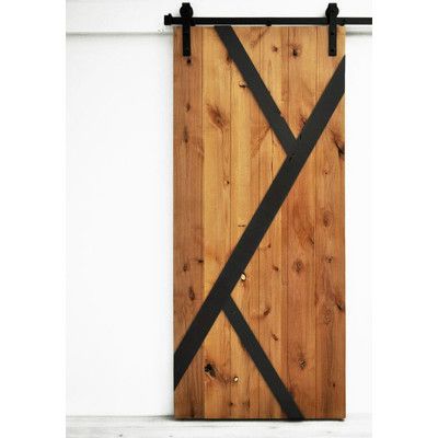 a close up of a wooden door with black straps on it's sides and a white wall in the background