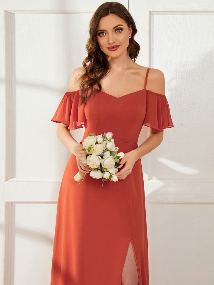 a woman in an orange dress holding a bouquet