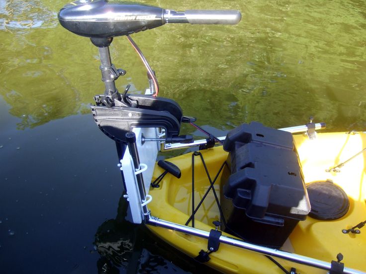 a yellow kayak in the water with an engine attached to it's side