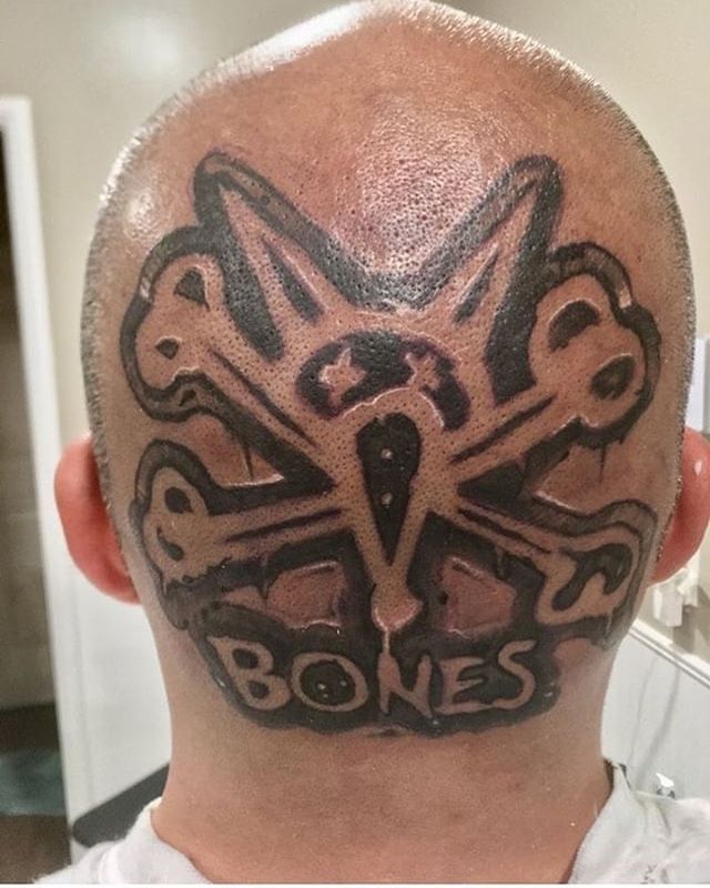 a man with a skull and bones tattoo on his head