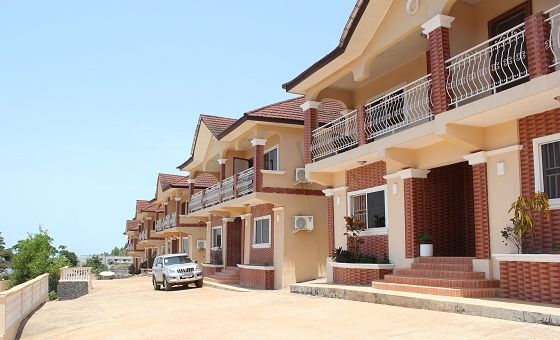 a car is parked in front of several brick buildings with balconies and balconies on the second floor