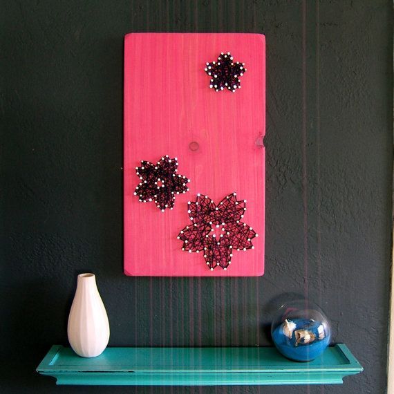 there is a pink and black wall with beads on it