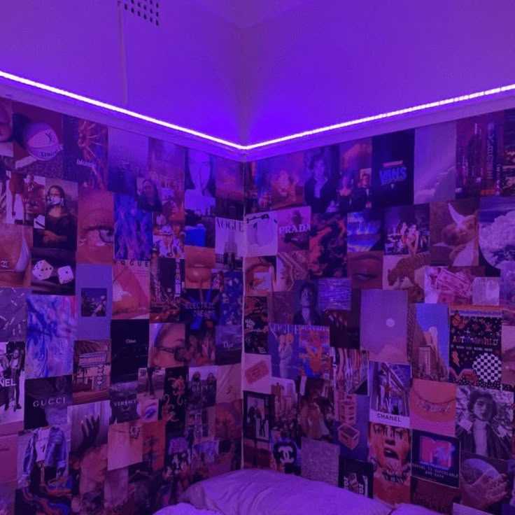 a bed in a room with purple lights and pictures on the wall behind it,