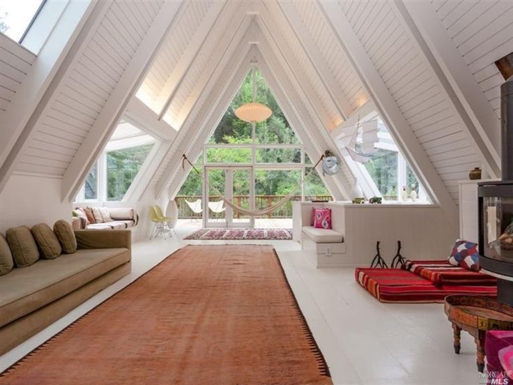 a living room filled with lots of furniture under a skylight in a loft type building