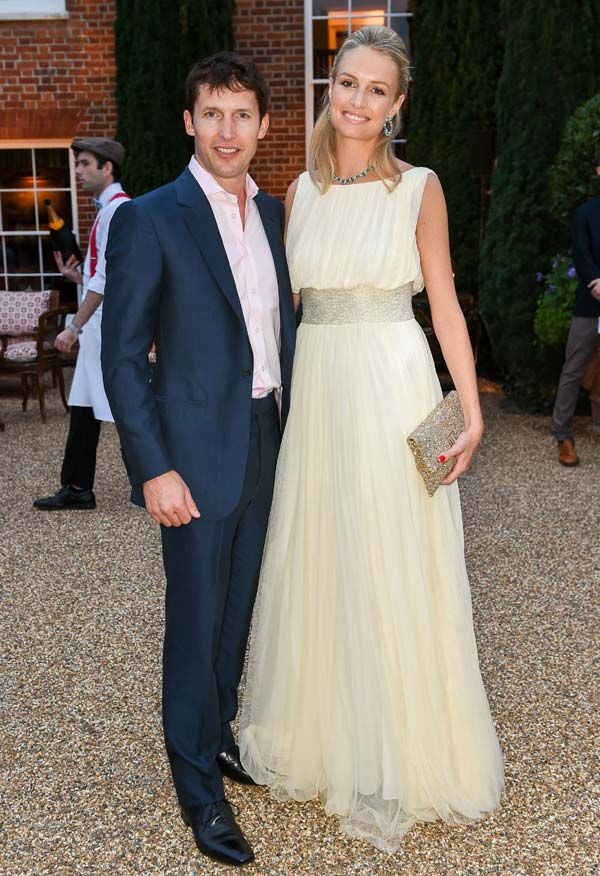 a man and woman standing next to each other in front of a brick building at an event