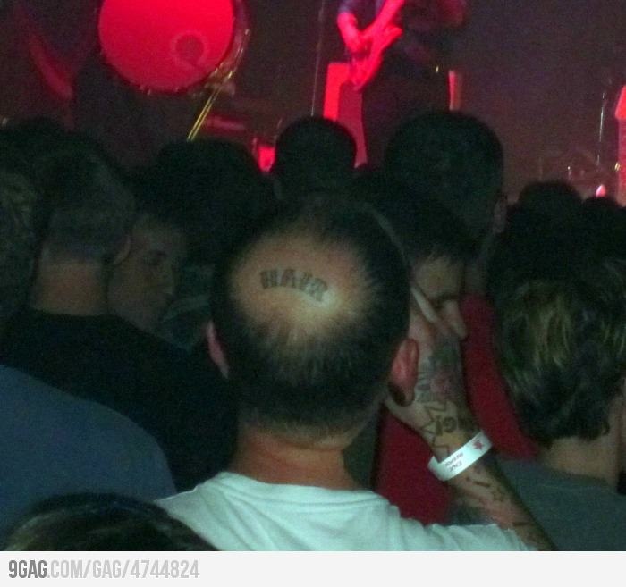 the back of a man's head with words written on his forehead in front of other people