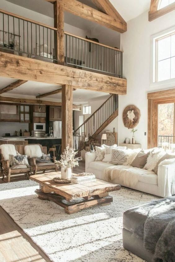 a living room filled with furniture and lots of wood beams on the ceiling, along with large windows