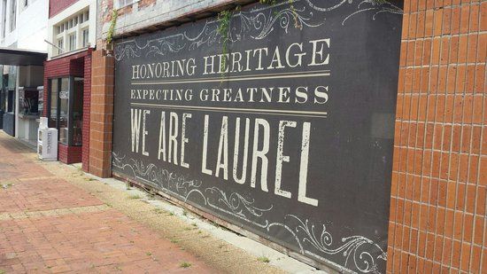 a sign on the side of a building that says, honoring heritage except greatness we are laurel