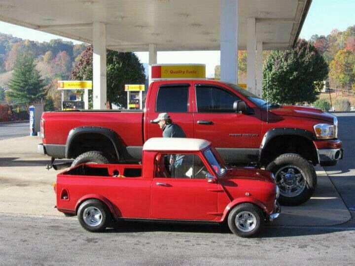 a red pickup truck parked in front of a gas station with a man standing next to it